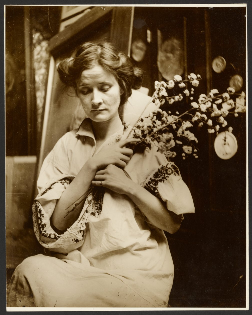 [Vrouwelijk model dat bloemen vasthoudt]. door Alphonse Maria Mucha
