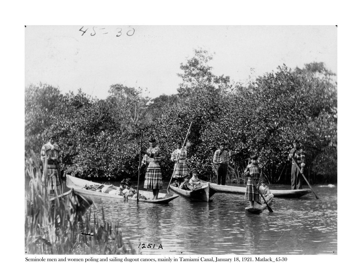 Seminole mannen en vrouwen die kano