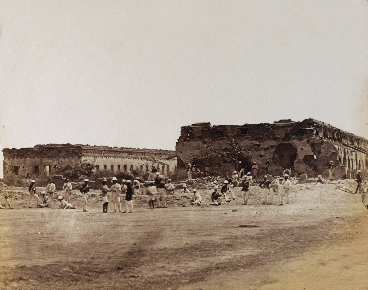 Indiase soldaten bij vernielde gebouwen, ca. 1858 (sepia foto) door English Photographer