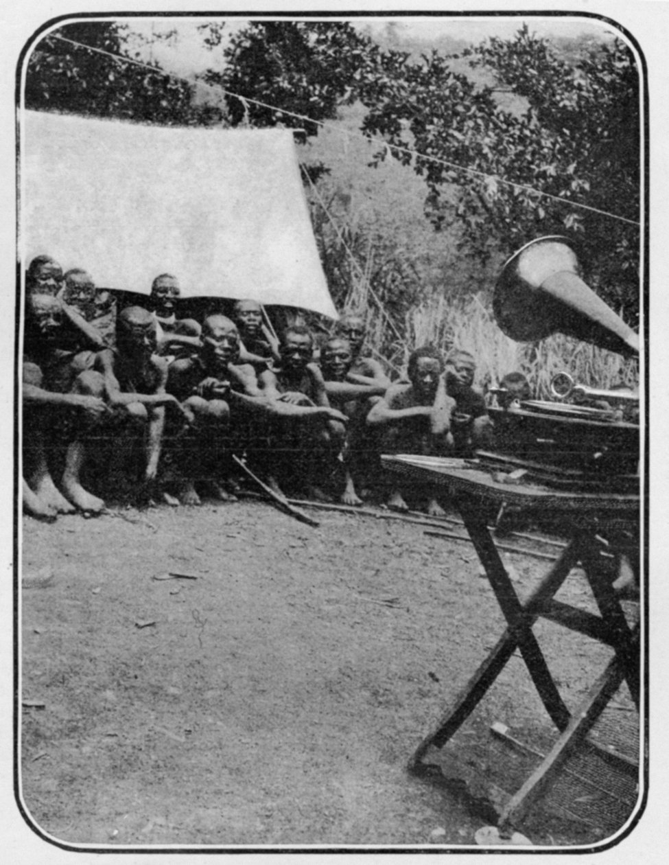 Witte Mannen Magie: De Grammofoon Verbaast de Wakonja Inheemsen, uit een artikel getiteld Naar de Bergen van de Maan gepubliceerd in The Graphic, 27 oktober 1906 door English Photographer
