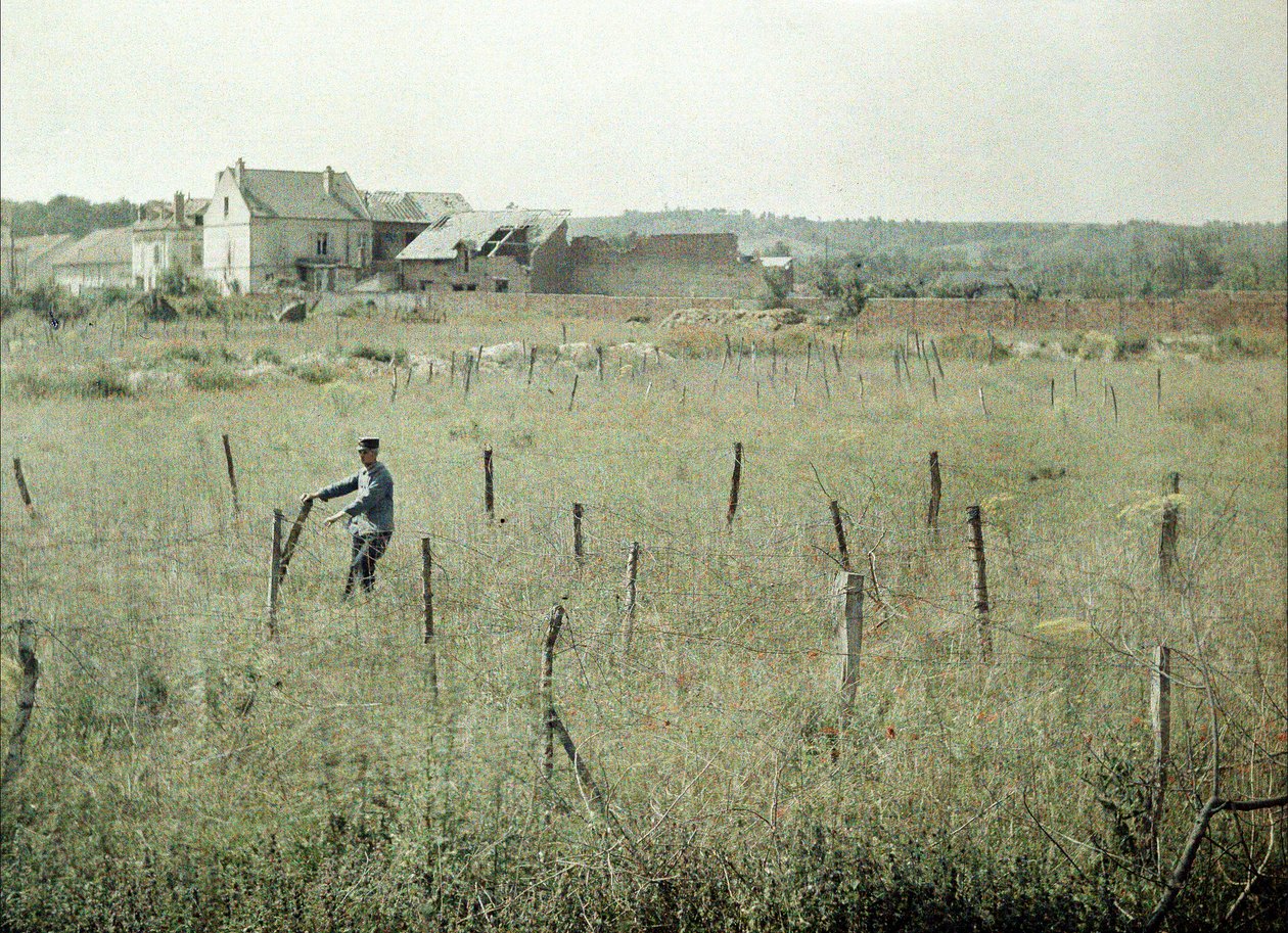Een Franse officier inspecteert het prikkeldraad rond Franse posities, Soissons, Aisne, Frankrijk, 1917 door Fernand Cuville