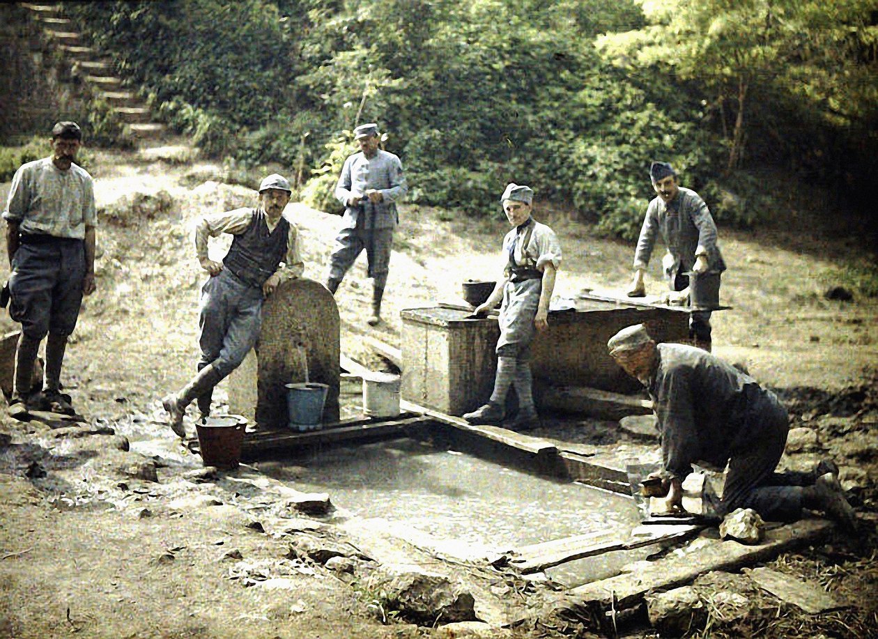 Zes Franse soldaten met emmers en wasgoed bij een fontein, Soissons, Aisne, Frankrijk, 1917 door Fernand Cuville