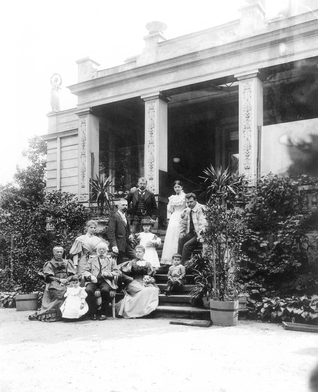 Max Klinger (1857–1920, op de foto linksboven) met zijn familie voor het huis van zijn ouders in Leipzig, Karl-Heine-Strasse 2 (tuinzijde) door Hermann Walter