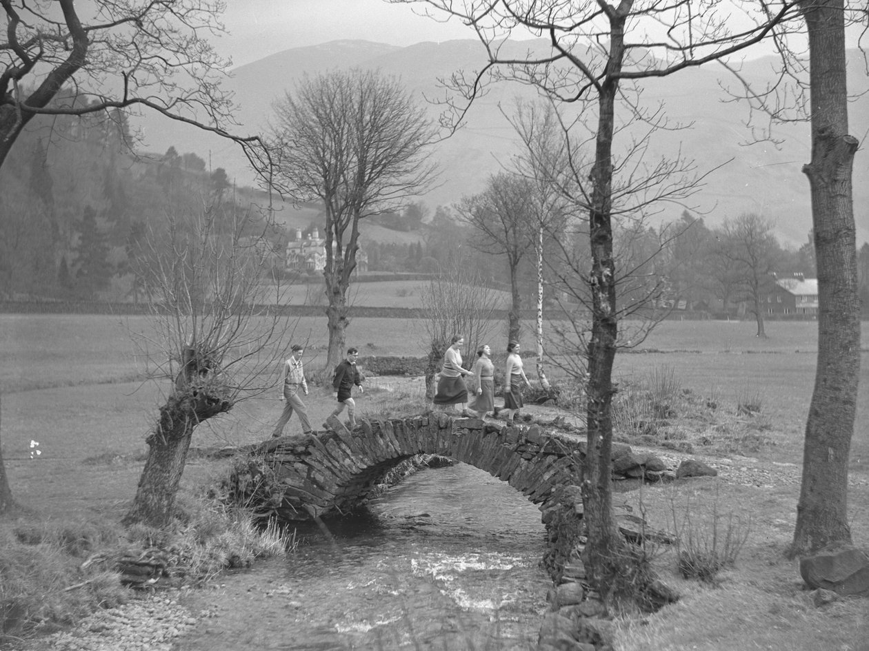 Groep jonge wandelaars loopt over brug door Joseph Hardman
