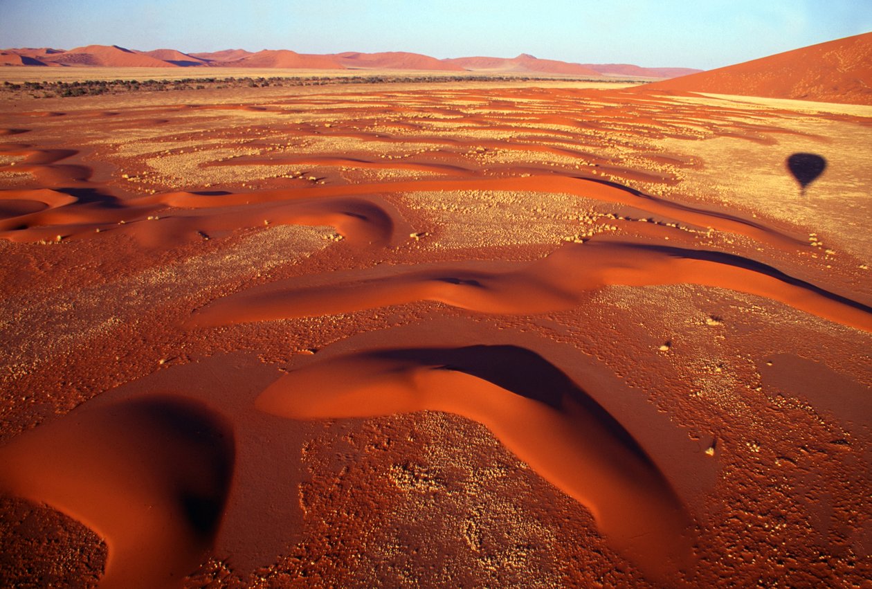 Uitzicht over een vallei van zandduinen vanuit een luchtballon net na zonsopgang nabij Sossusvlei in de Namibwoestijn, Namibië. 24-07-2003. door Unbekannt Unbekannt
