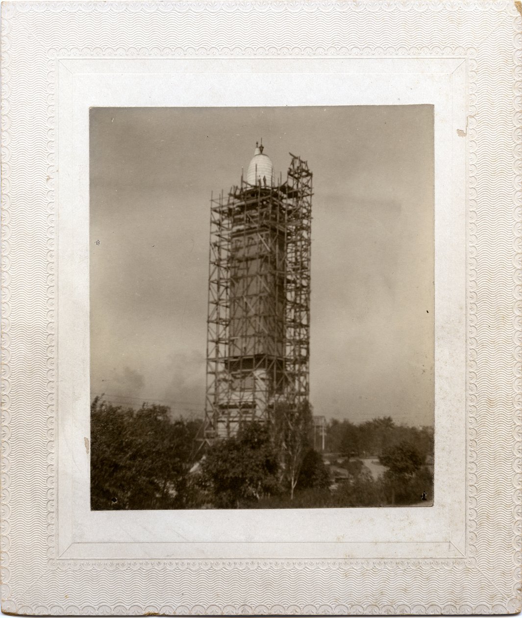 Bouw van de Compton Heights Watertoren over bestaande standpijp, met steigers rond de toren en een arbeider op dakniveau door Unknown